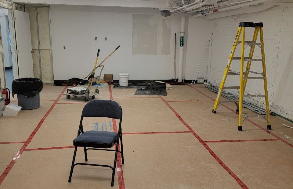 Facility renovation in progress with interior wall finishing and construction tools
