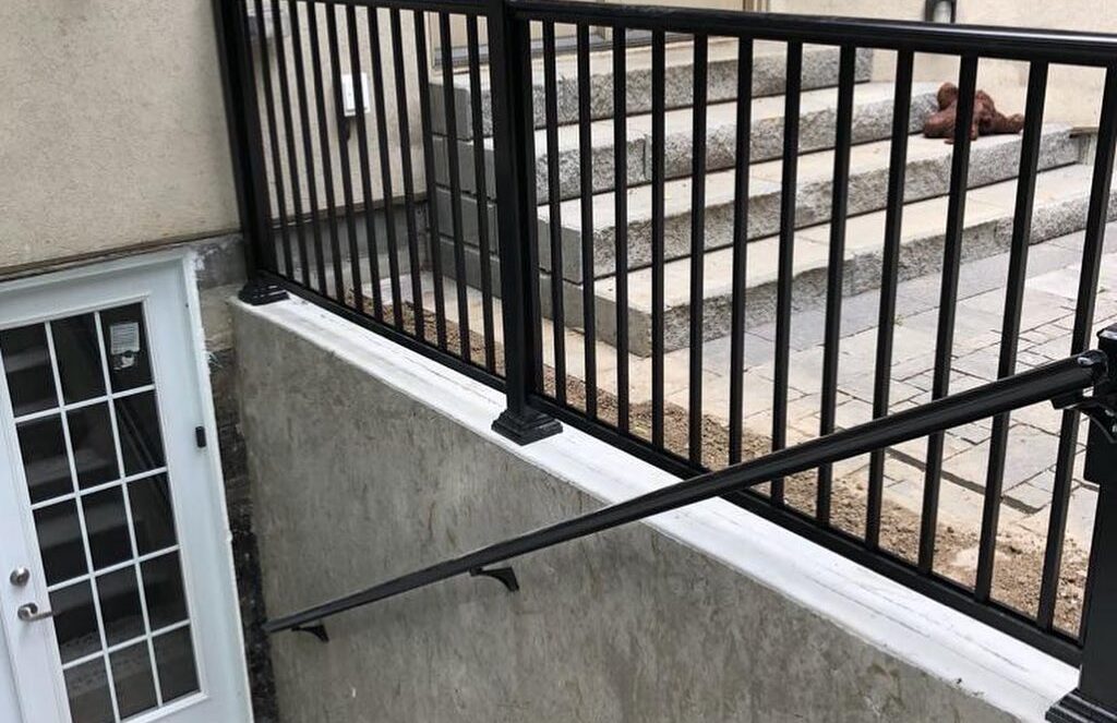 Basement entrance protected by black metal railing